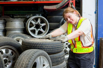 Mechanic is holding a tire inside a car repair garage