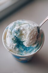 blue and white vanilla ice cream in a cup with a spoon