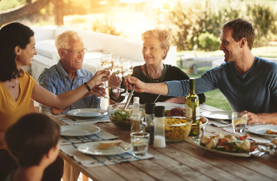 Food, love and large family with toast on patio for event, party or birthday celebration. Wine, cheers and group of people in backyard for brunch, bonding and support with reunion lunch for parents