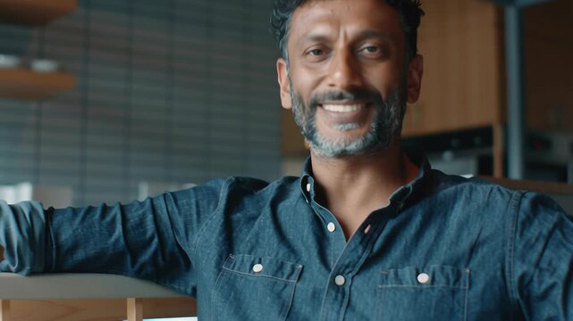 Natural light portrait of an Indian man in an everyday setting, relaxed posture, realistic proportions and expressions, minimal styling, documentary-inspired realism, honest and relatable mood