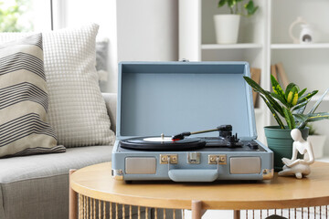 Record player and plant on table near sofa in living room
