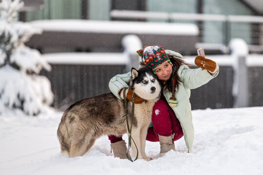 Asian woman and husky take selfie on Winter day.