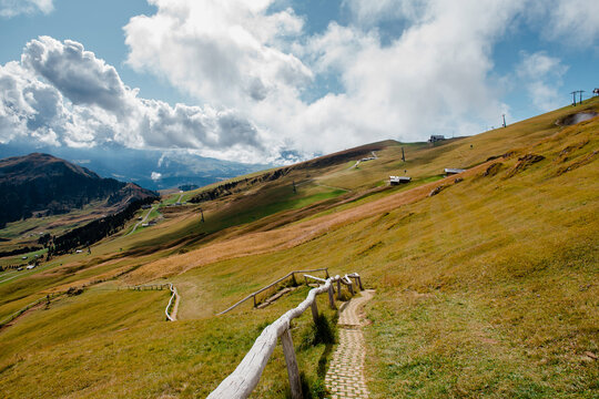 Seceda mountain with hiking path and clouds in the Dolomites