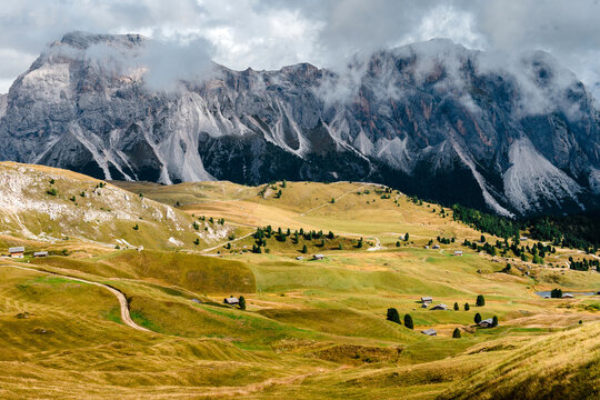 Seceda with rolling green hills and scattered chalets in the Dolomites