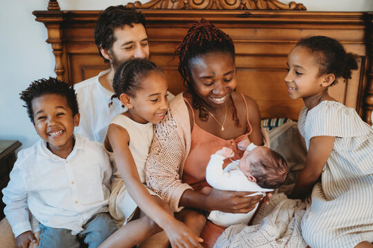 Large Multiracial family black mom white dad holding newborn