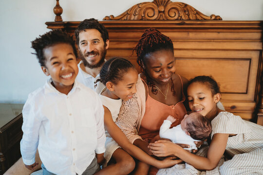 Large Multiracial family black mom white dad holding newborn