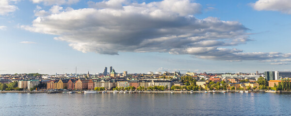 Naklejka premium Stockholm, Sweden skyline by the water with historic towers and green hills