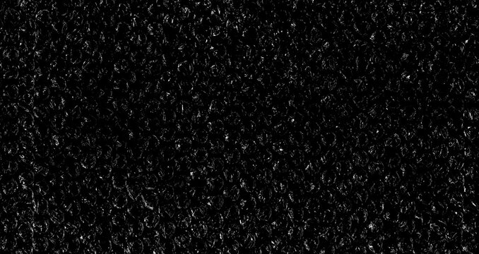 High contrast bubble wrap texture on black background with glowing light reflections. Abstract plastic pattern, futuristic industrial surface, dramatic lighting, creative packaging concept.