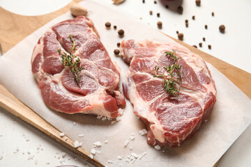 Fototapeta premium Wooden board with fresh raw steaks, thyme and peppercorns on white background, closeup