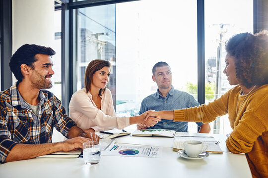Happy, people and meeting with paperwork, handshake and agreement for marketing manager recruitment. Creative, team and shaking hands with new employee, hiring or impressed with ad performance review