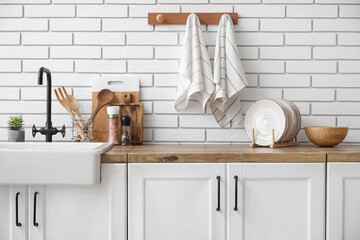 Clean napkins hanging on white brick wall in kitchen