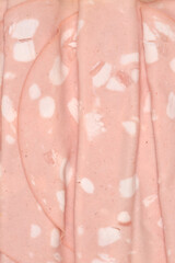 A vertical close up macro shot showing the detailed texture and white fat spots of thinly sliced...