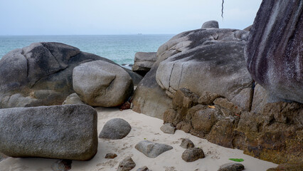 Detailed view of massive and ancient granite rock formations on the sand at Siangau Beach, Bangka Island, Indonesia