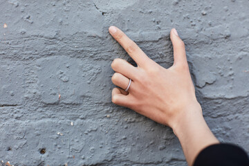 Person, hands and countdown with fingers for anniversary, engagement or save the date on brick wall. Closeup, marriage and counting with commitment, symbol or gesture for event, time or plan on space