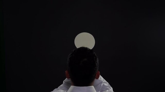 Priest Raising Consecrated Host During Holy Mass, Catholic Eucharist Elevation Ceremony