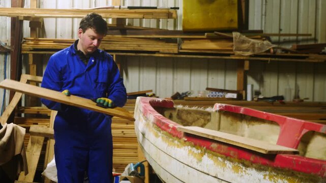 Carpenter wiping sanded oak planks with acetone