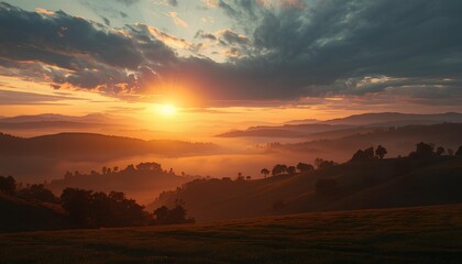 Dramatic sunset over rolling hills with mist and layered mountains, warm golden light and cloudy sky creating a peaceful natural landscape.