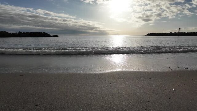 soft waves roll onto sandy beach in winter coastal village bogliasco in slow motion 120fps