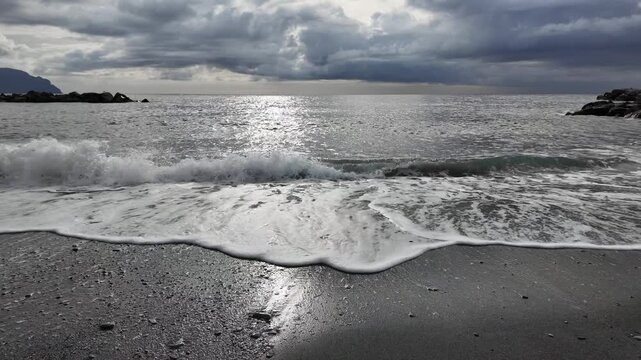 soft waves roll onto sandy beach in winter coastal village bogliasco in slow motion 120fps