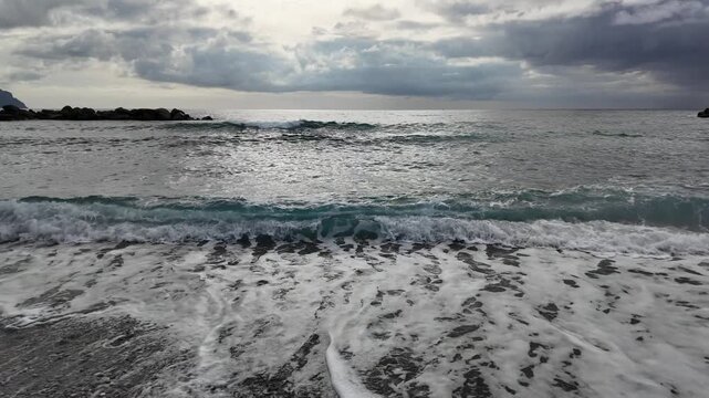 soft waves roll onto sandy beach in winter coastal village bogliasco in slow motion 120fps