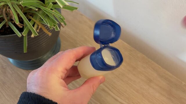 Man putting on applying vaseline to lips to lock in moisture, helping skin heal from dryness