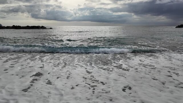 soft waves roll onto sandy beach in winter coastal village bogliasco in slow motion 120fps