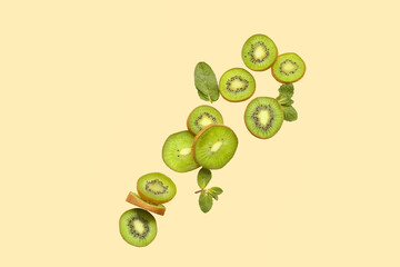 Cut ripe kiwi and mint leaves flying on color background © Pixel-Shot