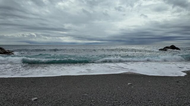 soft waves roll onto sandy beach in winter coastal village bogliasco in slow motion 120fps