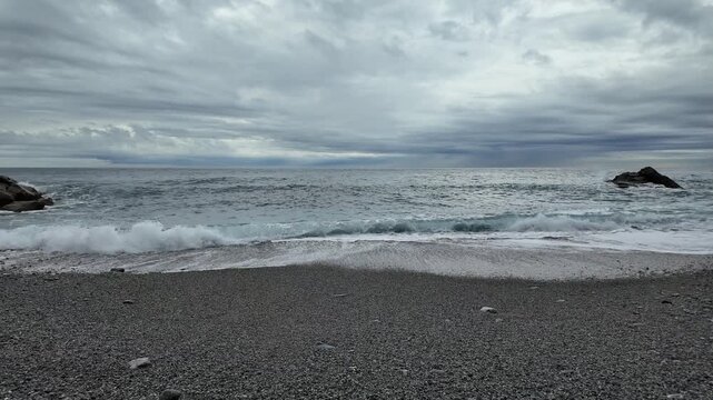 soft waves roll onto sandy beach in winter coastal village bogliasco in slow motion 120fps