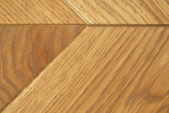 Close-up of French herringbone parquet flooring with different wood tones.