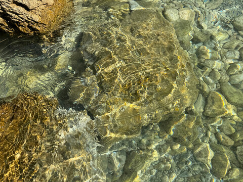 Stones and pebbles in clear sea water.