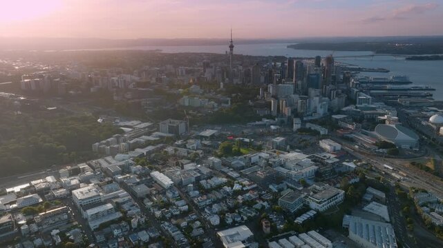 Aerial view of Parnell, Auckland, New Zealand, showcasing a mix of residential buildings, lush greenery, and the city skyline with the iconic Sky Tower. Captures urban life.