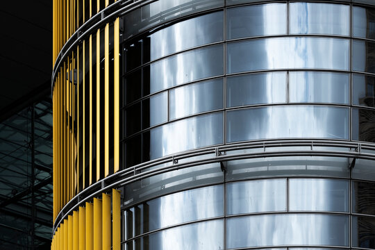 Modern corporate office skyscraper architecture facade with curved glass windows pattern and yellow fins on contemporary building exterior background