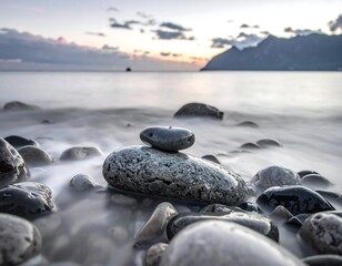 Serene coastal scene features stacked stones with soft water blur
