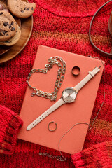 Composition with stylish female accessories, book and cookies on knitted sweater