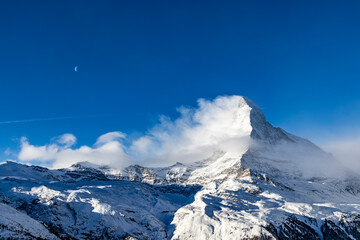 Snow covered Matterhorn and Cervino mountain peaks during winter in Zermatt Switzerland with clear...