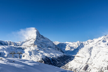Fototapeta premium Snow-covered Matterhorn and Cervino mountains in winter season with clear blue sky in Zermatt Swiss Alps