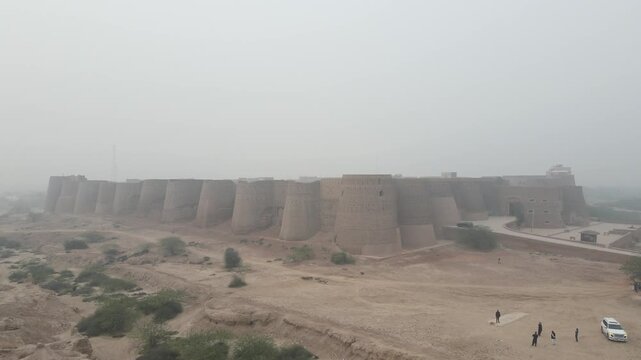 The drone flies towards the Derawar Fort in the fog of the winter season. 4K Drone Video. 