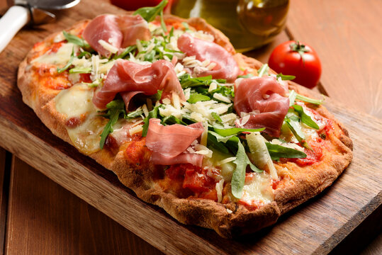 Pinsa romana con rucola, prosciutto crudo e scaglie di parmigiano, cibo italiano 