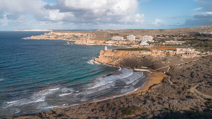 Stunning aerial perspective of Malta's rugged coastline, featuring Ghajn Tuffieha Bay, luxury...