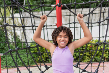 Fototapeta premium Happy child playing on climbing net during children's day celebration