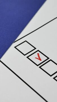 Voter ticks box next to their candidate on paper ballot with red marker. Democratic elections in the EU. Blue flag of the European Union with stars on background
