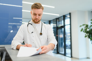 Doctor writing medical notes at hospital reception