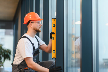 Builder installing window, ensuring precise level measurement