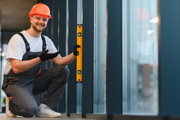 Construction worker using bubble level for measurement