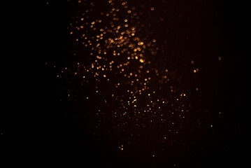 Obraz premium Golden abstract bokeh on black background.