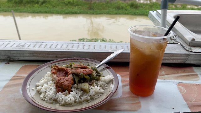 Tasty meal with refreshing iced tea by river