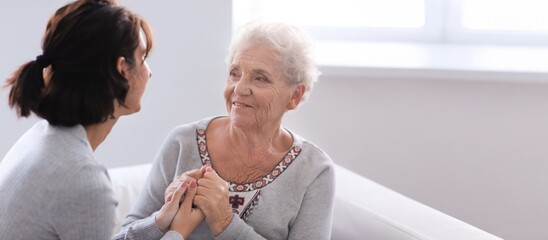 Happy elderly woman with her daughter at home