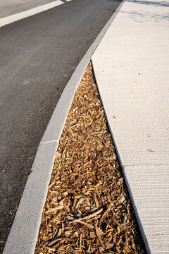 Minimal urban ground texture where sidewalk curb meets asphalt and concrete edge showing clean lines for modern street background design