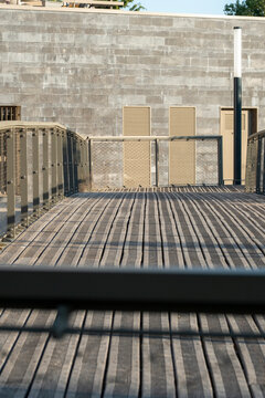 Urban architecture terrace deck with wood planks and concrete railing lines lead strong perspective creating minimal outdoor space texture